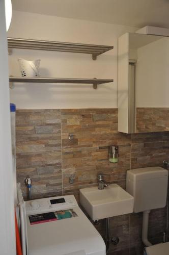 a bathroom with a sink and a toilet and a mirror at Apartment Gordana in Cres