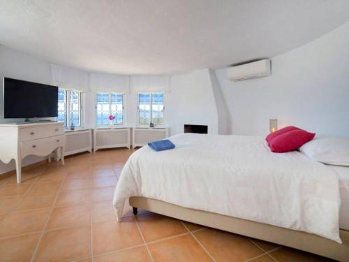 1 dormitorio con 1 cama blanca y TV en Villa BLANCA en Altea