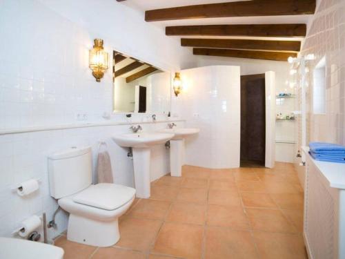 Baño blanco con aseo y lavamanos en Villa BLANCA en Altea