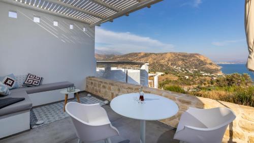a white table and chairs on a balcony with a view of the ocean at Galini Breeze in Agia Galini