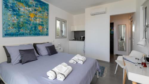 a bedroom with a large bed with towels on it at Galini Breeze in Agia Galini