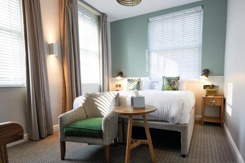 a bedroom with a bed and a chair and a table at Middletons in York