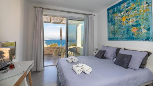 een slaapkamer met een bed en uitzicht op de oceaan bij Galini Breeze in Agia Galini