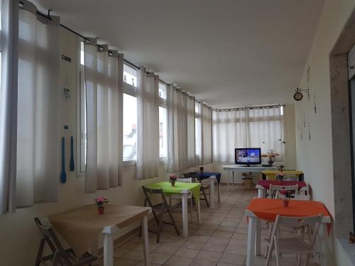 a room with tables and chairs and a television at B&B Jamba self ceck in in Alghero