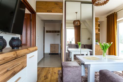 a kitchen and living room with a table and chairs at Apartamenty Ciche Wzgórze Zakopane in Zakopane