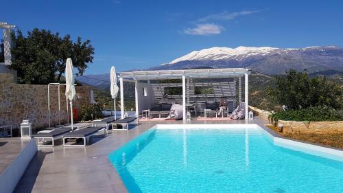a swimming pool with a mountain in the background at Galini Breeze in Agia Galini