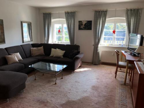 uma sala de estar com um sofá e uma mesa de vidro em Ferienwohnung König Max em Bad Alexandersbad