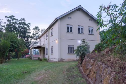 a large white house with a wall at Sunrise Apartments Hotel Fort Portal in Fort Portal