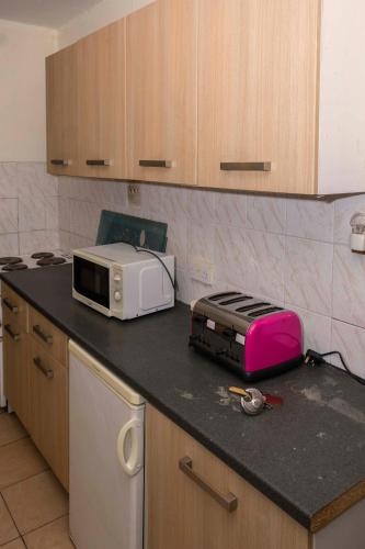 a kitchen with a counter top with a toaster and a toaster oven at Sunrise Apartments Hotel Fort Portal in Fort Portal
