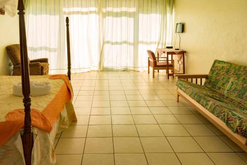 a living room with a bed and a couch at Sunrise Apartments Hotel Fort Portal in Fort Portal