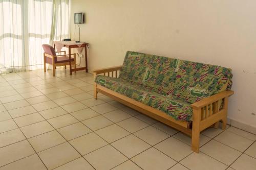 a living room with a couch and a chair at Sunrise Apartments Hotel Fort Portal in Fort Portal