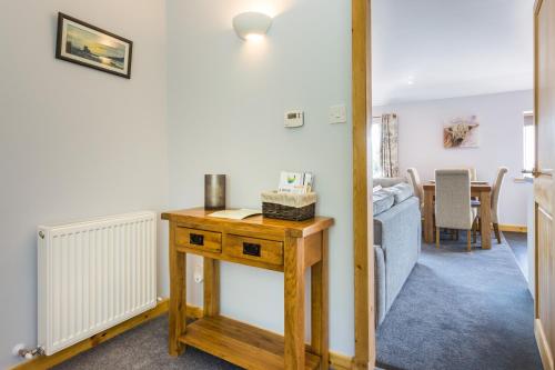 a living room with a wooden table and a couch at Oakbank Farm in Lamlash