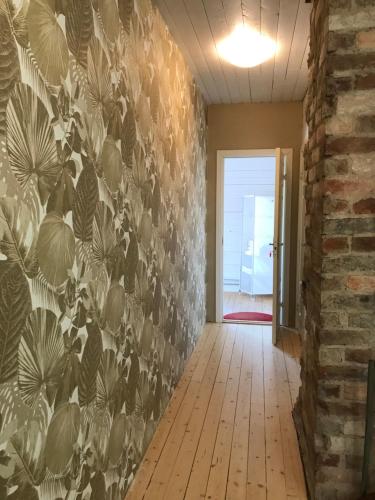 a hallway with a wall with a floral wallpaper at Vintergatans Rum in Insjön