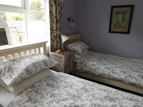 a bedroom with two beds and a window at UPTHEDOWNS B&B in Sevenoaks