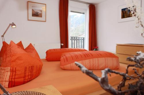 巴赫的住宿－Fewo Enzian，卧室配有2个橙色枕头