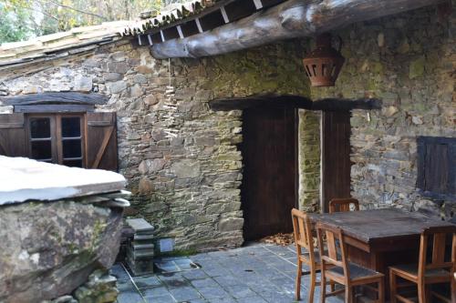 a stone house with a table and chairs outside at Casa Javali in Chiqueiro
