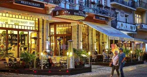 a couple walking down a street in front of buildings at Salvator Hotel in Karlovy Vary