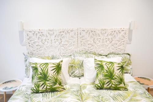 un letto con lenzuola e cuscini verdi e bianchi di Belém River Apartment R/C a Lisbona