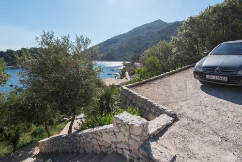 a car parked on a retaining wall next to a lake at House Daniva in Okuklje