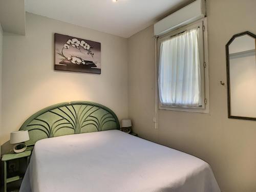 a bedroom with a white bed and a window at Cozy Apartment sea view Air Cond in Golfe-Juan