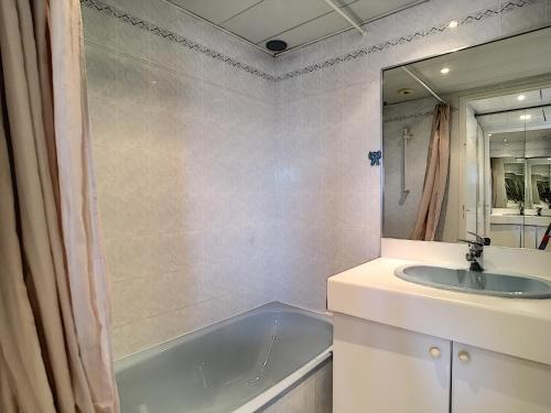 y baño con bañera, lavabo y espejo. en Cozy Apartment sea view Air Cond, en Golfe-Juan