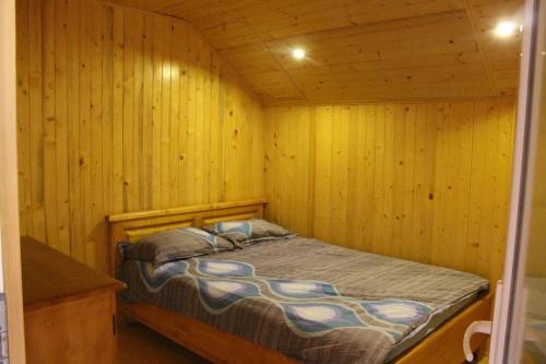 a bedroom with a bed in a wooden cabin at Ardelean Lake House in Doştat