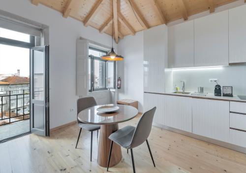 a kitchen and dining room with a table and chairs at Oporto Street Sá de Noronha in Porto