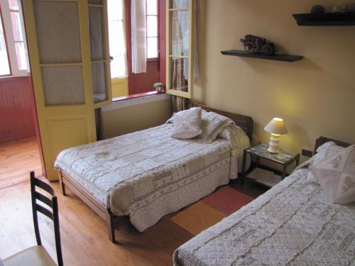 a bedroom with two beds and a table with a lamp at El Mirador De Valparaiso in Valparaíso