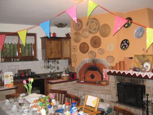 eine Küche mit einem Tisch und einem Kamin mit Platten an der Wand in der Unterkunft Il Giuggiolo in Calco