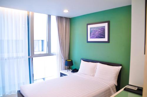 una camera con letto e parete verde di Minh Khang Hotel ad Ho Chi Minh