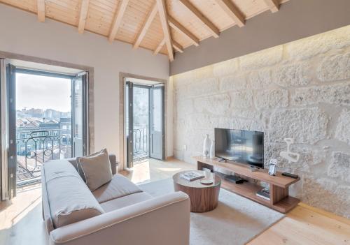 a living room with a couch and a tv at Oporto Street Sá de Noronha in Porto