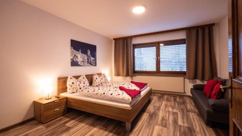 a bedroom with a bed and a couch and a window at Ferienhaus Krismer in Fügen