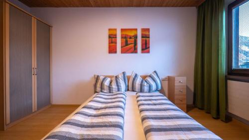 a bedroom with two beds and two paintings on the wall at Ferienhaus Krismer in Fügen