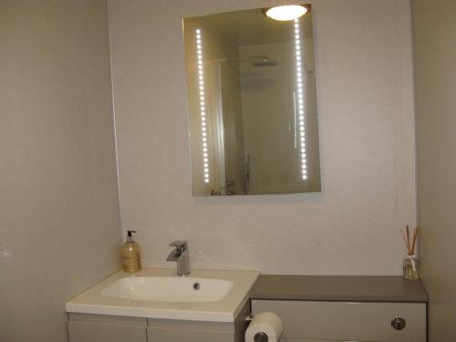 a bathroom with a white sink and a mirror at Seabreeze Apartment in Keiss