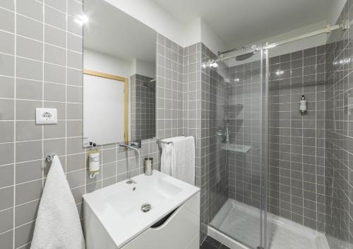 a bathroom with a white sink and a shower at Oporto Street Sá de Noronha in Porto