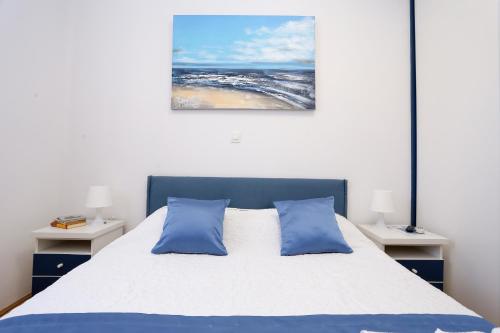 um quarto com uma cama com almofadas azuis e um quadro em Luxury Apartment ELA em Split