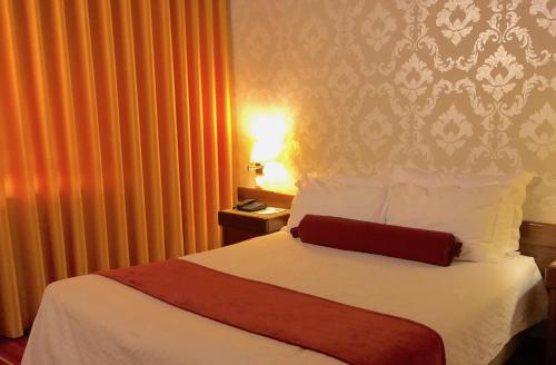 a hotel room with a bed with a red blanket at Hotel Eurosol Seia Camelo in Seia