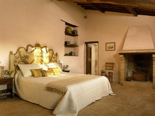 a bedroom with a large bed and a fireplace at Borgo di Pianciano in Spoleto