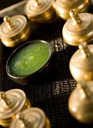 a group of gold and green candles on a table at The Kayana in Seminyak