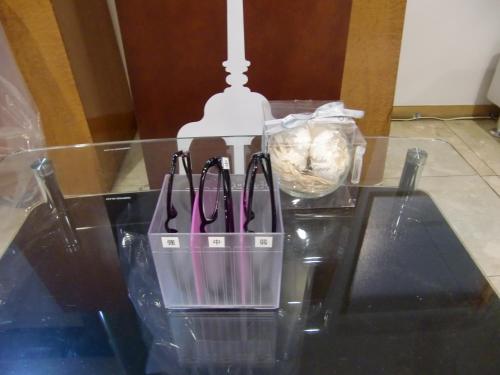 a glass table with a container with pens on it at Hotel Abest Shin-Anjo-Ekimae in Anjo