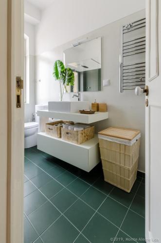 a bathroom with a sink and a toilet and a mirror at Casa do Tamariz, XIX century Beach House in Estoril