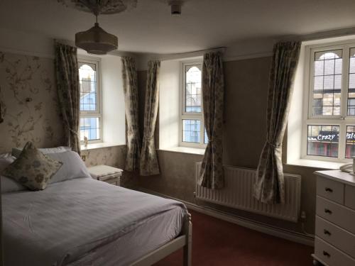 1 dormitorio con 1 cama y 3 ventanas en Riverside Guesthouse en Charlestown