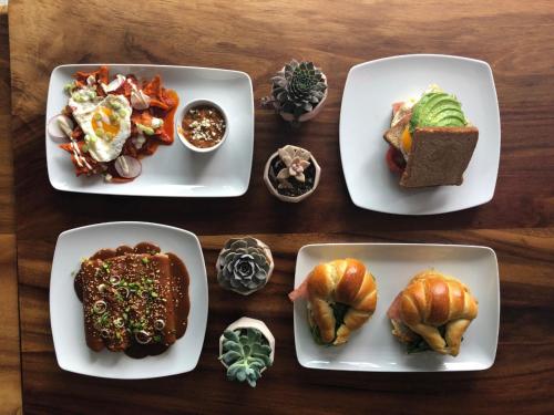 three plates of food on a wooden table at FCH Hotel Expo Adults only in Guadalajara