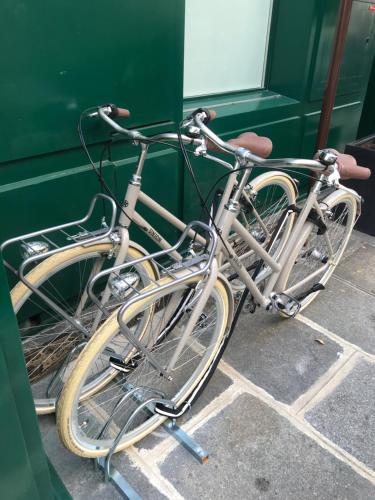 two bikes are parked next to a green wall at Hotel Splendide Royal Paris - Relais & Châteaux in Paris