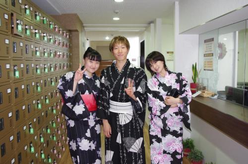 three women in kimonos standing in a hallway at Hanabi Hotel in Tokyo