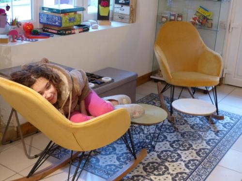a little girl laying in chairs in a living room at Chambre d'hôtes Logis de Saint Jean in Bayeux