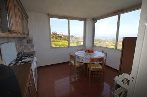 a kitchen with a table with a bowl of fruit on it at Appartamento Terry - Casa vacanze in Capo Vaticano