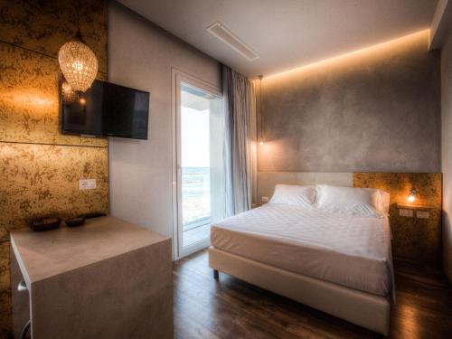a small bedroom with a bed and a window at Bell Suite Hotel in Bellaria-Igea Marina