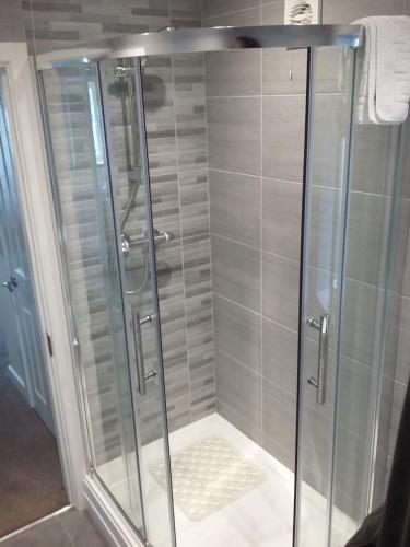 a shower with a glass door in a bathroom at Harrington Flats in Newquay