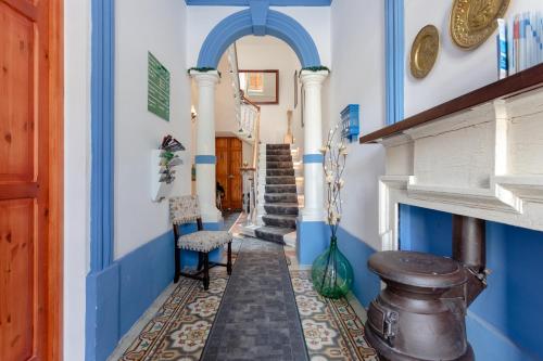 a hallway with blue and white walls and stairs at Maleth Inn in Rabat